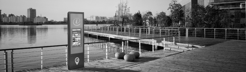 un totem interactif en extérieur à côté d'un plan d'eau